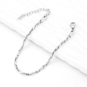 Detail of silver twisted chain bracelet with lobster clasp and adjustable link on stone surface