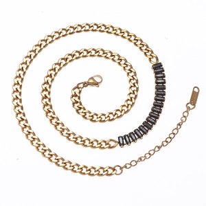 Macro detail of 18K gold stainless steel Cuban chain with black zircon stone and lobster clasp