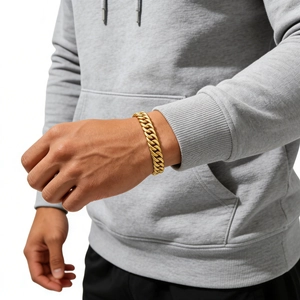 Detailaufnahme eines dicken goldenen Panzerarmbands für Herren am Handgelenk