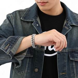 Nahaufnahme eines polierten Edelstahl-Panzerarmbands am Handgelenk eines Models