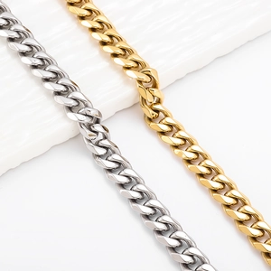Detailed view of polished gold and silver cuban link chains on white ceramic plate
