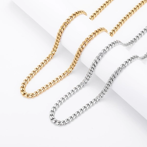 Polished silver and gold stainless steel Cuban link chains on minimalist white stones
