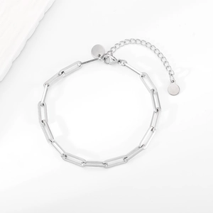 Detailansicht eines silbernen Büroklammer-Armbands mit Karabinerverschluss und Anhänger