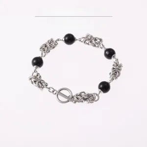 Detail of cross chain bracelet with black obsidian beads and a vintage toggle clasp
