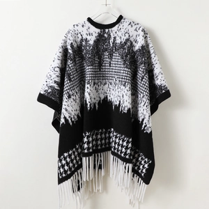 Black and white houndstooth knit shawl cape with geometric patterns and long white tassels