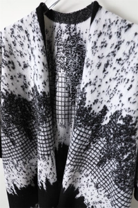 Detail of black and white houndstooth cashmere-feel shawl with pixelated ink patterns