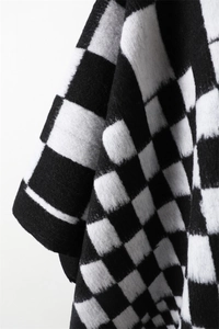 Detailed close-up showing the soft cashmere-like knit texture and classic checkerboard pattern