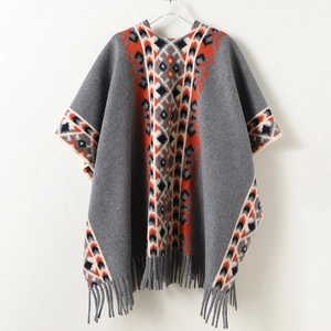 Close-up of geometric knit patterns and tassel fringe on a bohemian style shawl