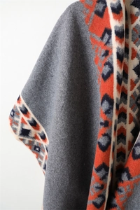 Detail of grey cashmere-like shawl showing ethnic patterns and soft fabric texture