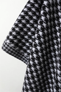 Macro shot of black and white houndstooth cashmere texture and soft fabric drape