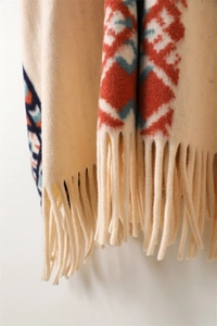 Detailed view of bohemian geometric pattern and thick fringe on beige pashmina shawl