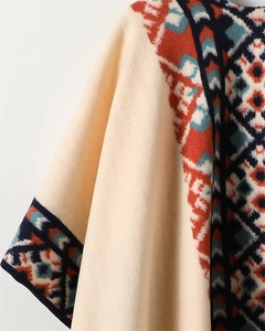 Detailed texture of bohemian ethnic pattern on white cashmere-feel shawl with fringe