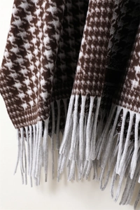 Close-up detail of houndstooth wool shawl featuring coffee brown patterns and grey tassels