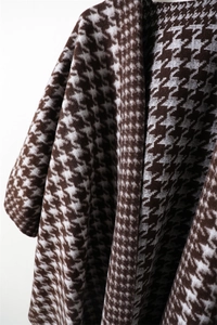 Close-up of classic houndstooth cashmere-feel shawl with elegant brown fringe details