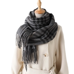 Classic houndstooth cashmere shawl with tassels over a white coat for winter
