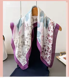 Detailed view of elegant floral printed faux silk scarf draped on a wooden hanger