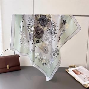 Detail view of the floral print silk scarf showing soft drapes and hand-drawn patterns