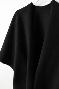 Détail de la texture d'un châle en maille noire épaisse imitant le cachemire de luxe