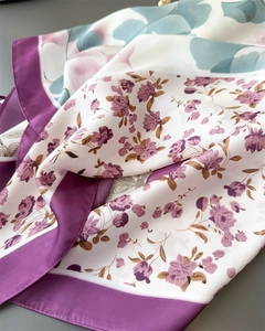 Close-up of floral satin scarf with purple border and elegant silk-like texture details