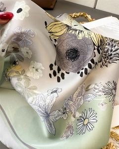 Detail of floral printed silk scarf showing soft texture and premium satin luster