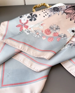 Detailed view of the elegant floral print and smooth satin texture on the silk-like scarf