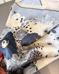 Detailed macro view of soft satin scarf texture with elegant blue floral print