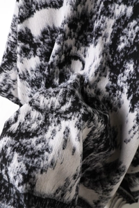 Close-up of black and white ink wash pattern on cashmere-like shawl with fine fringe