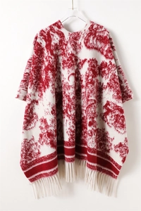 Detail of red ink-wash pattern and white tassel fringe on cashmere-like poncho wrap