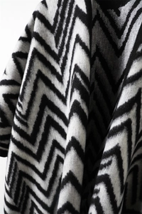 Close-up of black and white zigzag pattern shawl with soft cashmere texture and tassels