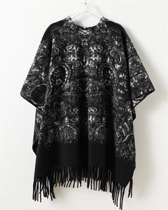 Detailed view of black and white vintage jacquard knit shawl with dense fringe hem