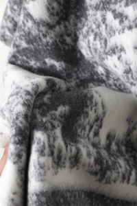 Macro detail of soft cashmere-like fabric showing black and white ink pattern texture