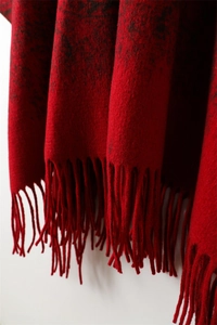 Close-up of red and black vintage pattern cashmere scarf fabric with elegant tassel fringe