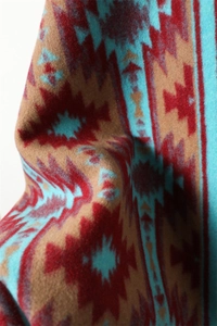 Detail of bohemian geometric pattern shawl showing thick cashmere-like texture and tassels