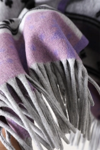 Close-up of thick geometric deer shawl showing soft cashmere-like texture and grey tassels