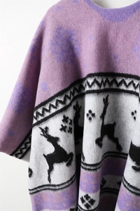 Detail of purple knitted shawl with reindeer patterns and soft jacquard fabric texture