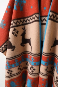Close-up of geometric deer pattern and snowflake knit texture on a winter shawl