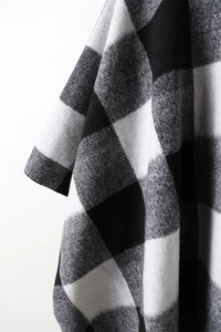 Close-up of black and white buffalo plaid scarf with soft cashmere-like texture details