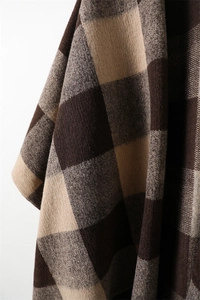 Detailed close-up of British plaid cashmere-feel scarf with soft fringe and knit texture