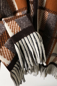 Detailed close-up of vintage plaid scarf texture with soft warm fringe and wool-like fabric