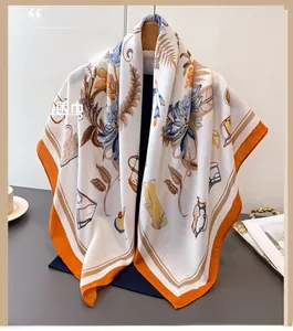 Detail of silk-like floral square scarf with orange borders on a wooden hanger