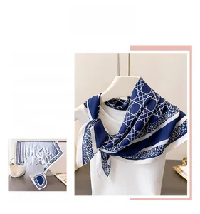 Vue détaillée des motifs géométriques et floraux sur cet élégant foulard en soie bleu