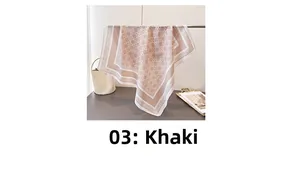 Détail d'un foulard en soie kaki à motif géométrique sur un support de présentation