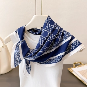 Vue détaillée d'un foulard en soie à motifs géométriques et léopard sur un gilet blanc