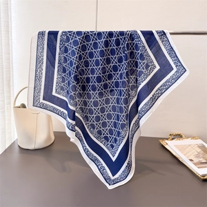 Détail d'un foulard bleu à motif de losanges géométriques et bordure imprimé animal