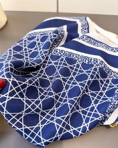 Détail d'un foulard en soie bleu marine avec motif cannage, imprimé léopard et chaîne dorée