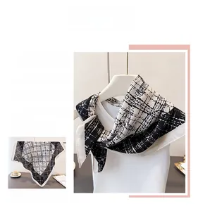 Detail of black and white checkered silk scarf with premium edge stitching and texture