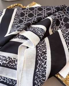 Détails de la texture du foulard en soie à carreaux géométriques noirs et blancs et léopard