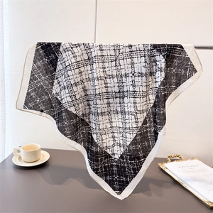 Elegant black and white geometric square scarf with star pattern on a display stand