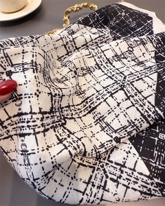 Detailed view of black and white plaid scarf fabric texture and soft weave material