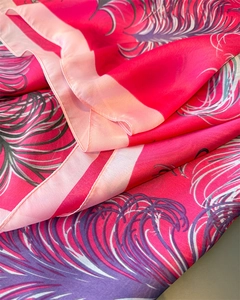 Nahaufnahme von glattem rosa Seidenschal mit lila Federmuster und weichem Stoffdetail
